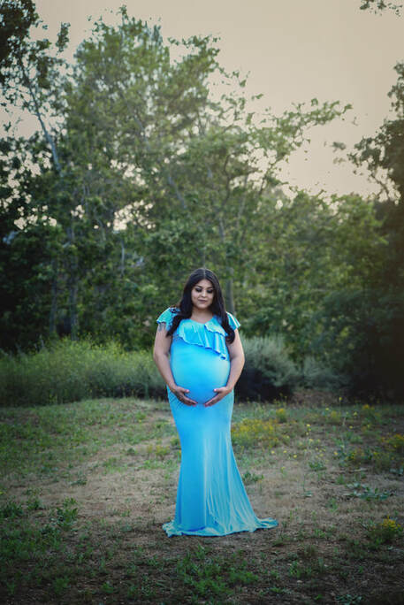 Expectant Mama outside in a baby blue maternity gown 