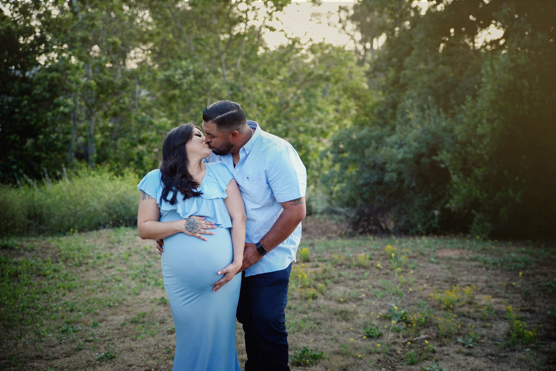 Mama- and Daddy-to-be outside in a baby blue maternity gown 