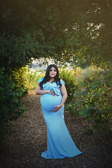 Mama-to-be outside in a baby blue maternity gown 